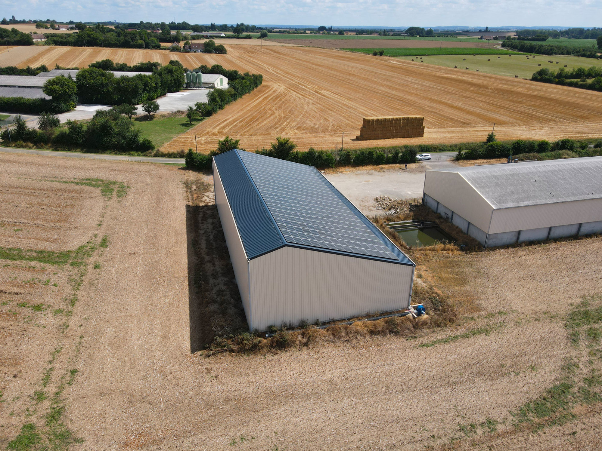 Conception asymétrique d'un bâtiment agricole solaire par Le Triangle, illustrant une approche innovante de l'agrivoltaïsme.